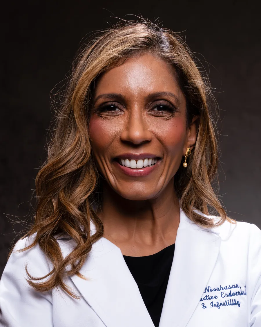 Dr. Noorhasan in her white coat, arms folded